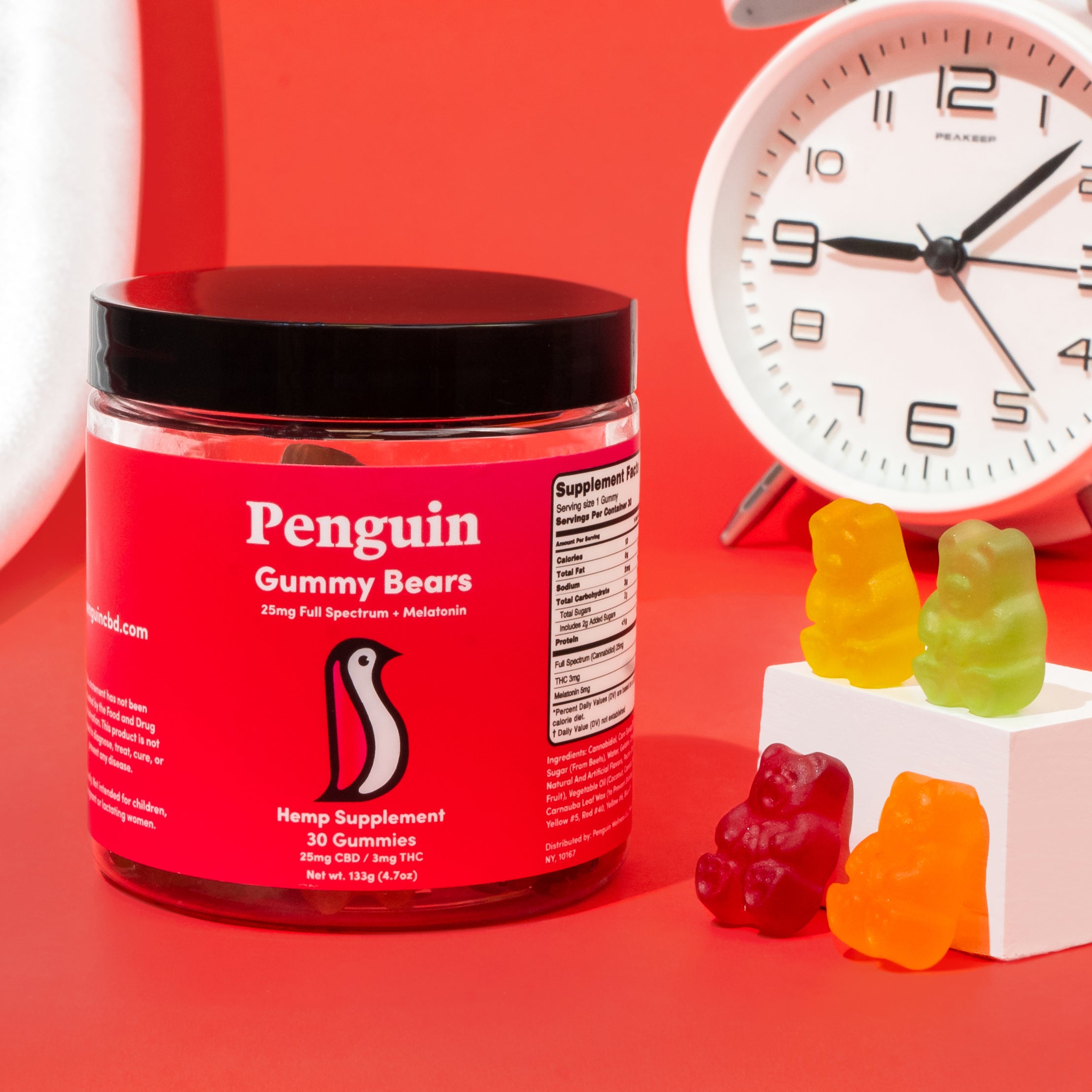 Jar of Penguin CBD Gummy Bears supplement with gummy bears and a clock on a red background